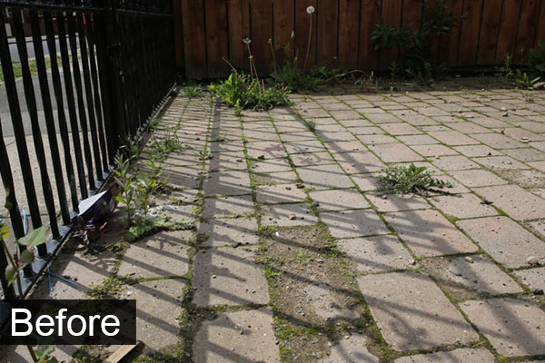 Block paving, before jet washing, showing dirt and weeds.