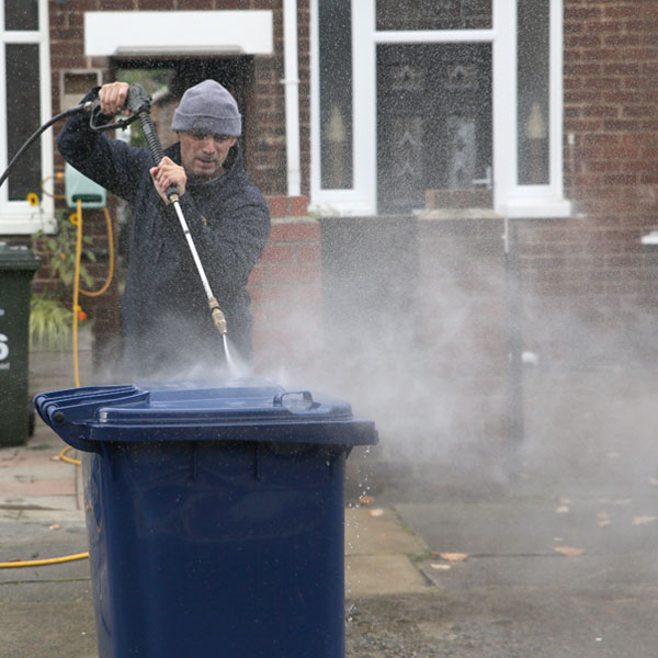 Cleaning of wheelie bins with jet wash.