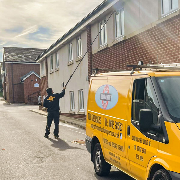 Brush and pole system being used to clean the windows and uPVC fascias of a residential home.