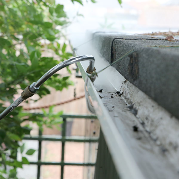 Spray cleaning gutter after gutter-vac.