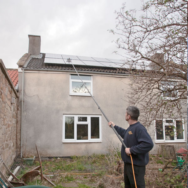 Long reach pole cleaning solar panel.